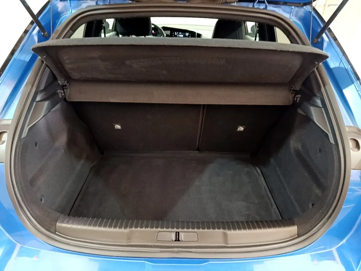 Vue arrière du coffre ouvert d’un Opel Mokka bleu 2024, montrant l’espace de chargement vide et la tablette cache-bagages relevée.