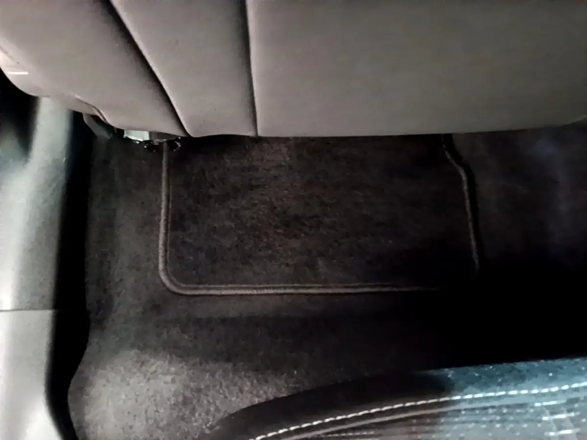 Vue intérieure du sol arrière avec tapis noir sous le siège arrière de l'Opel Mokka 2024 bleu.