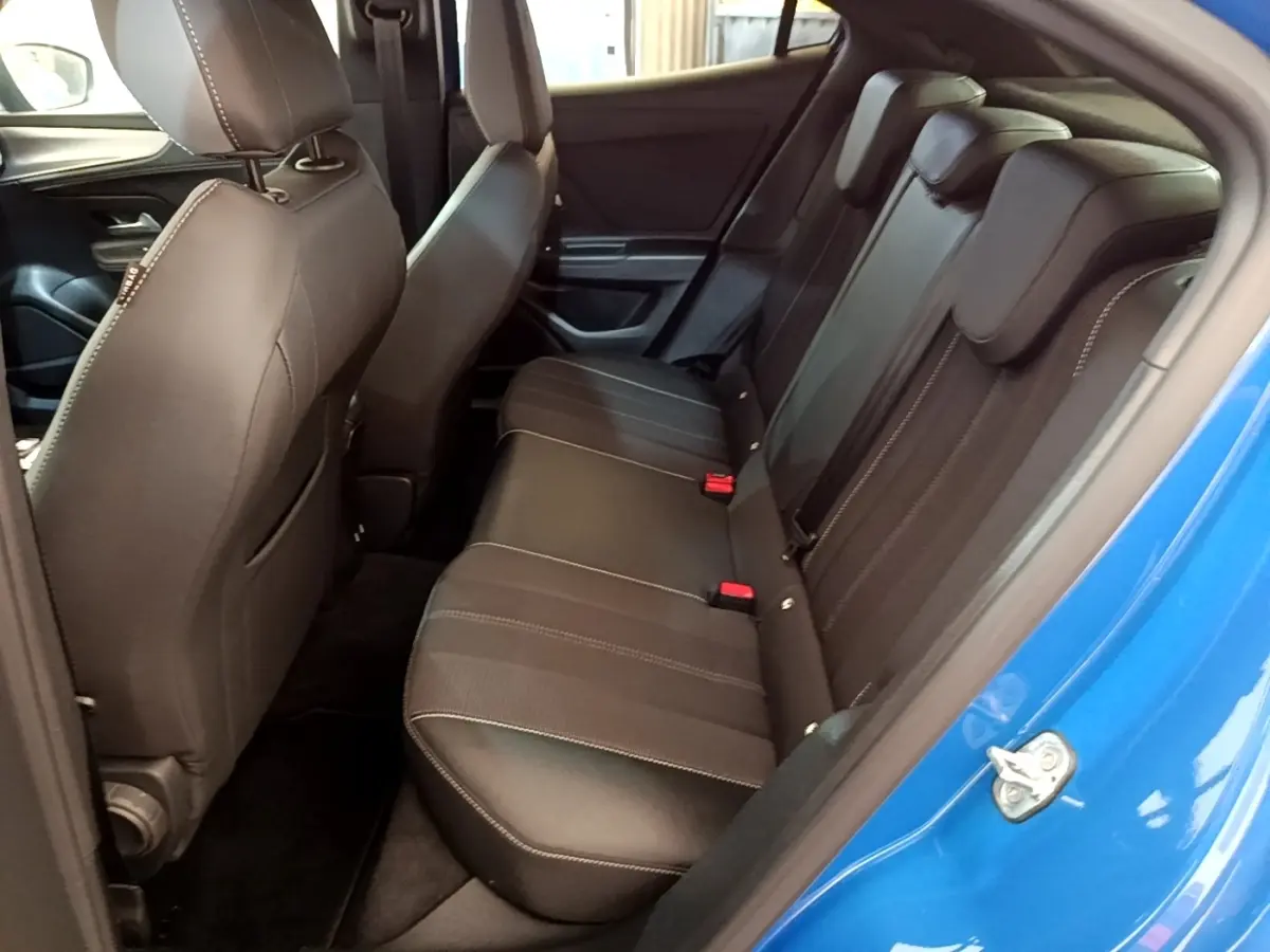 Vue intérieure côté droit sur la banquette arrière noire avec surpiqûres blanches d’un Opel Mokka bleu 2024.