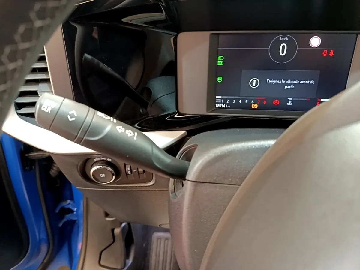 Vue rapprochée du combiné d'instruments numérique et du commodo gauche dans un Opel Mokka bleu 2024.