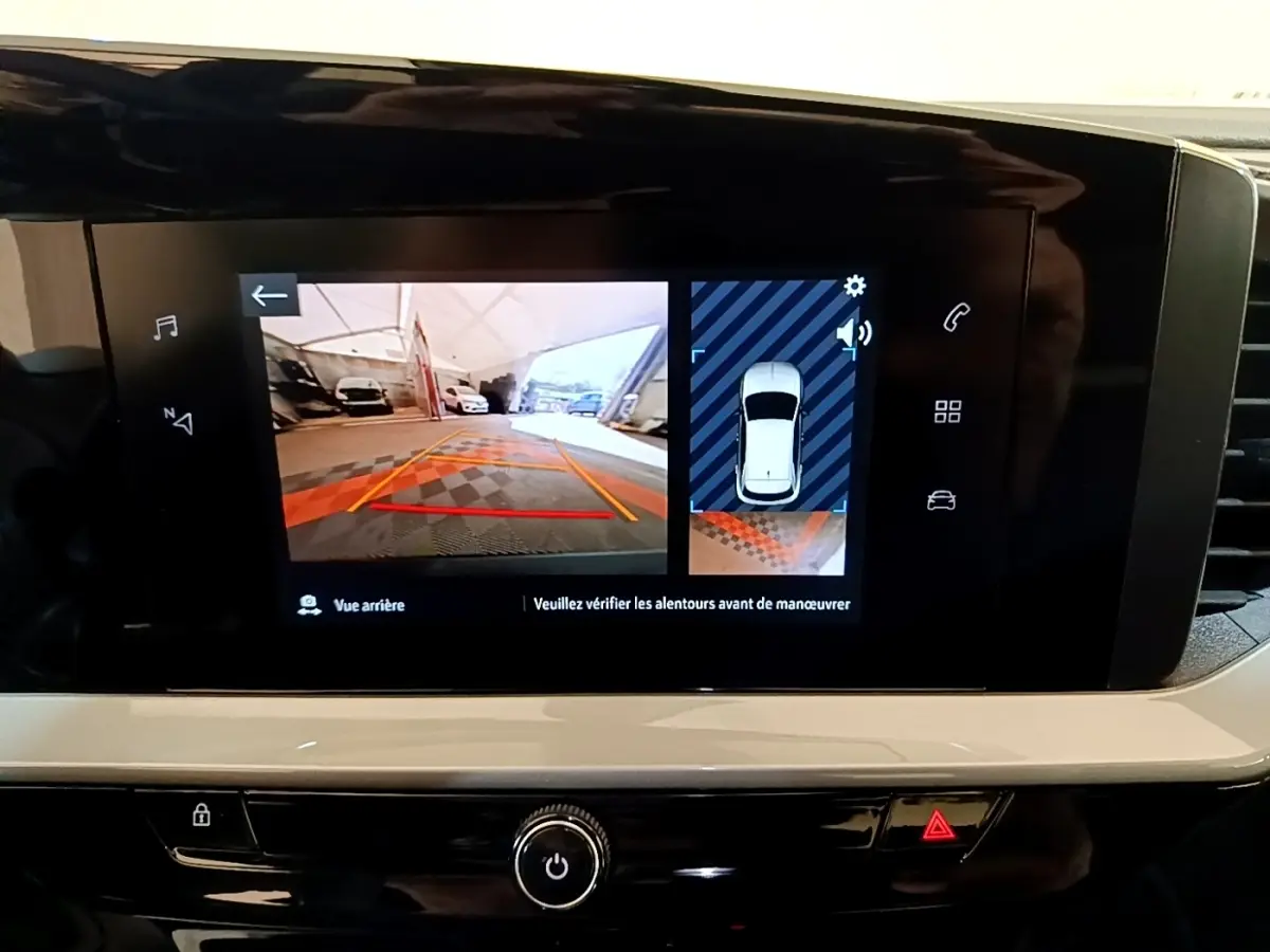 Écran tactile central affichant la caméra de recul et l'aide au stationnement du tableau de bord de l'Opel Mokka bleu.