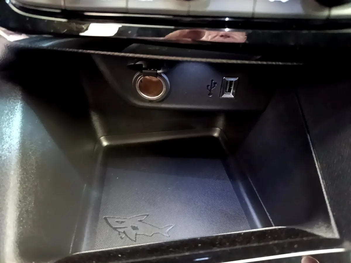 Gros plan sur la prise 12V et port USB dans le compartiment de rangement intérieur de l’Opel Mokka bleu.
