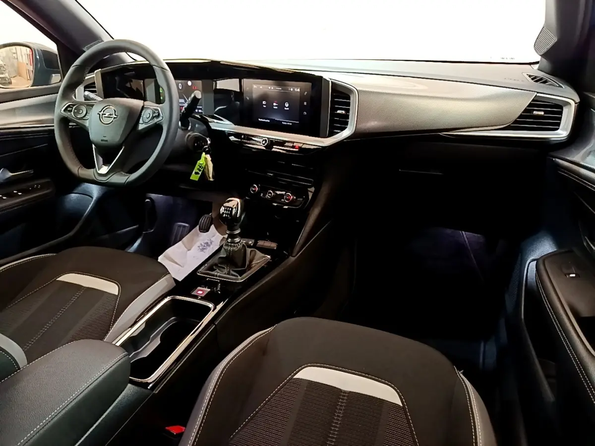 Vue intérieure avant droite de l’Opel Mokka 2024, avec tableau de bord moderne et boîte manuelle visible.