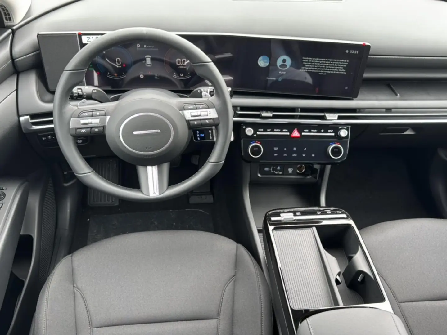 Vue intérieure du tableau de bord et volant multifonction noir du Hyundai Tucson 2026 avec écran tactile large et console centrale épurée.