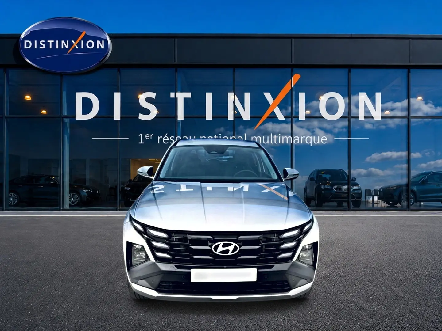 Vue frontale d’un Hyundai Tucson blanc 2026 avec calandre noire et logo Hyundai bien visible.