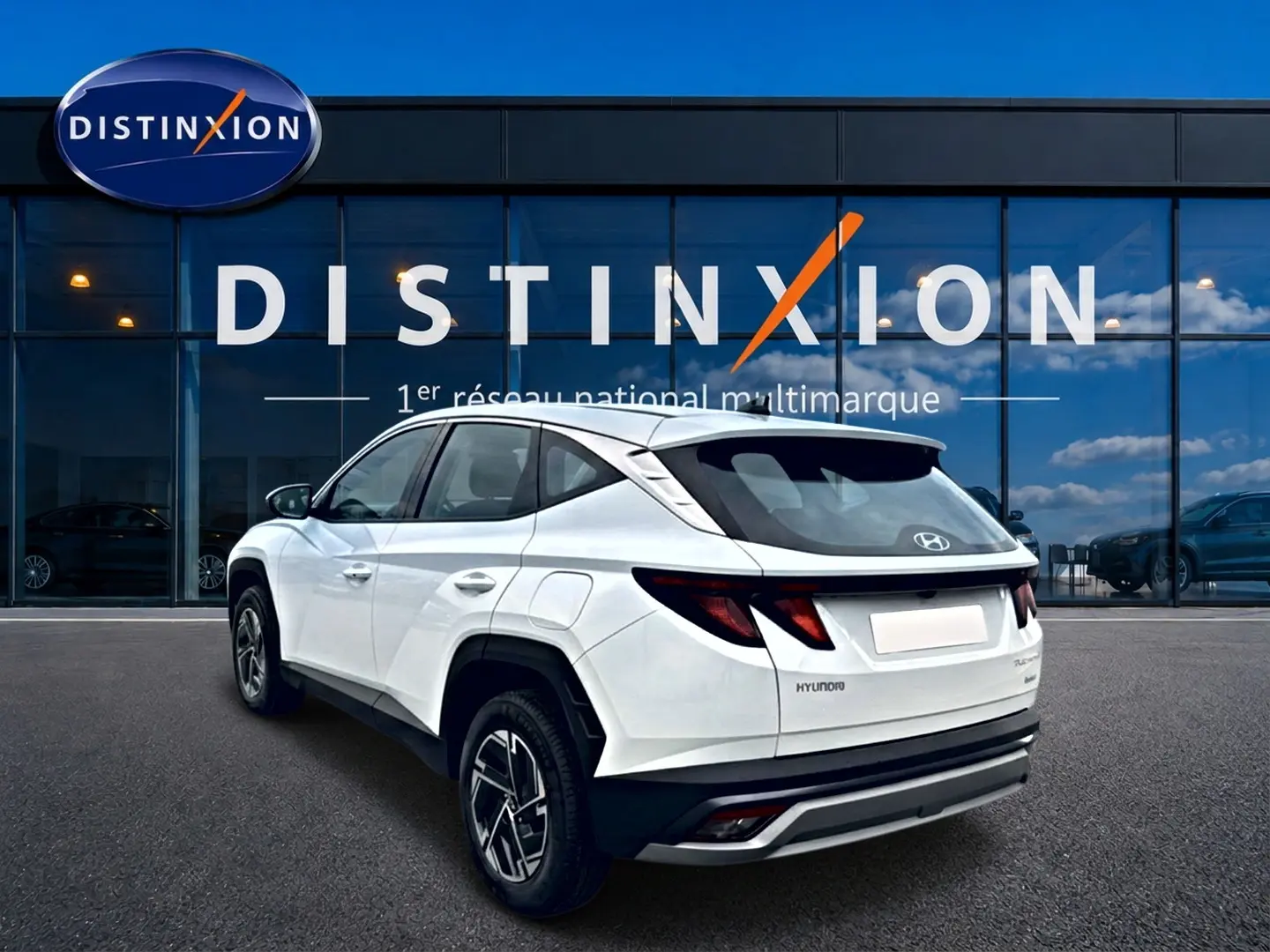Vue 3/4 arrière droite d'un Hyundai Tucson blanc 2026 avec jantes alliage et feux arrière LED distinctifs.