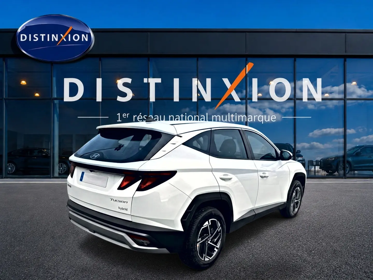 Vue 3/4 arrière droite du Hyundai Tucson blanc hybride 2026 avec jantes alliage et feux arrière LED distinctifs.