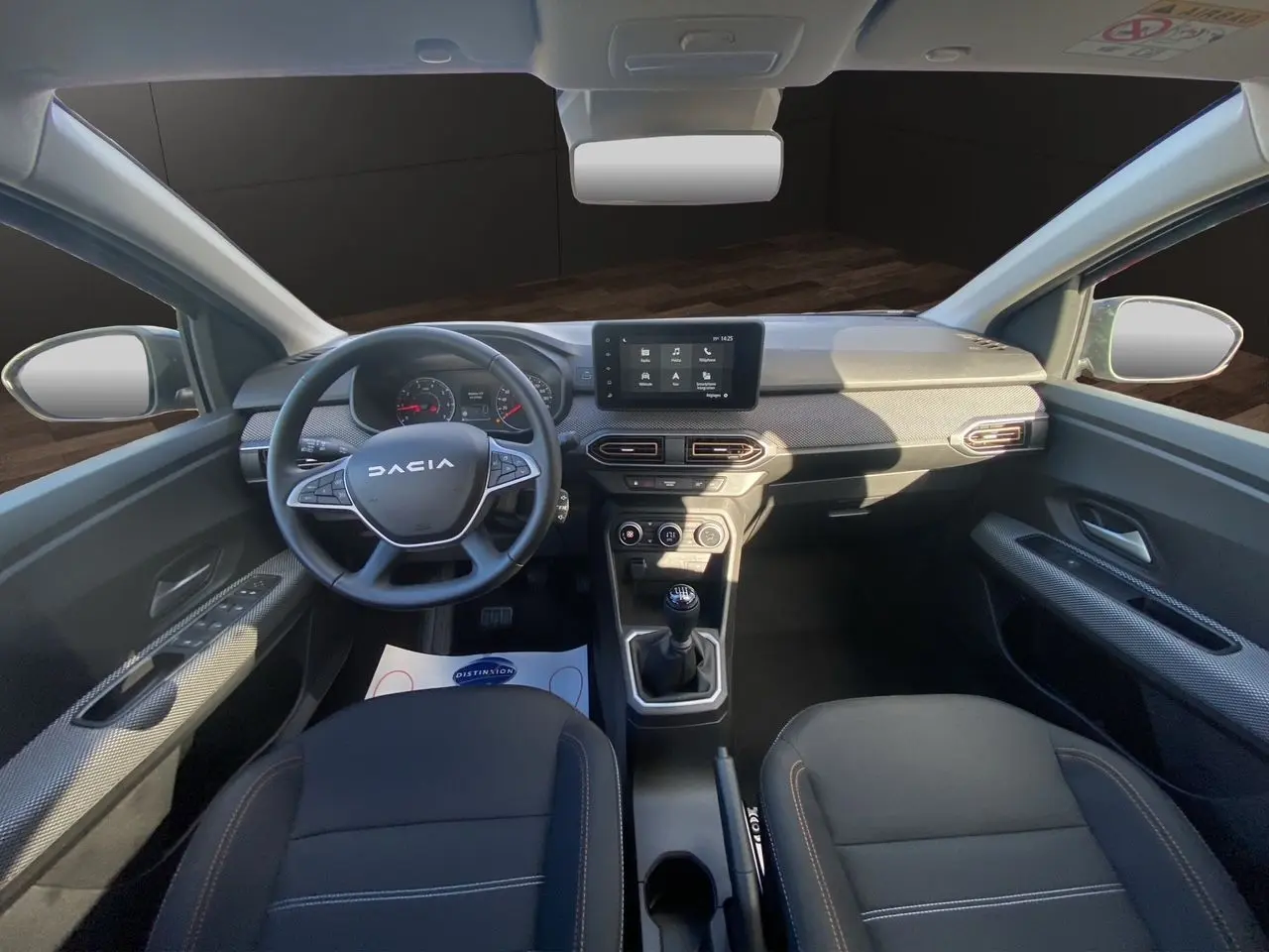 Vue intérieure avant de la Dacia Sandero Stepway 2025, tableau de bord noir avec écran tactile Media Nav et volant multifonction.