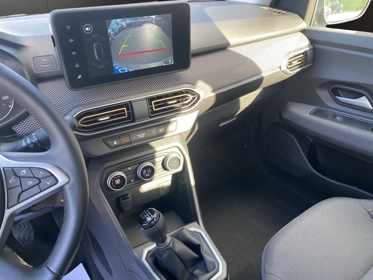 Vue intérieure côté conducteur de la Dacia Sandero Stepway noire, écran Media Nav affichant la caméra de recul et boîte manuelle.