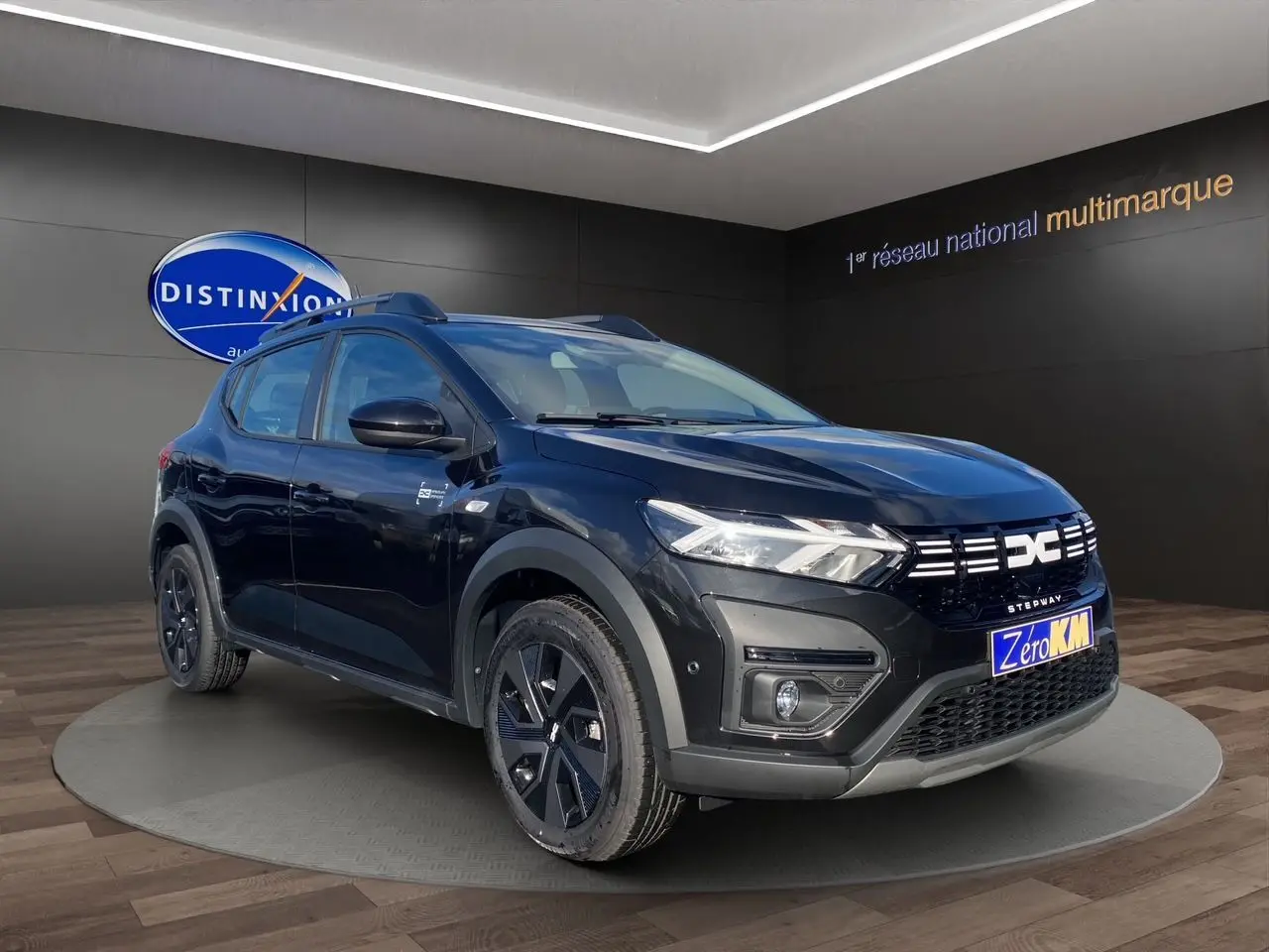 Vue 3/4 avant gauche d'une Dacia Sandero Stepway noire avec barres de toit et calandre distinctive LED.