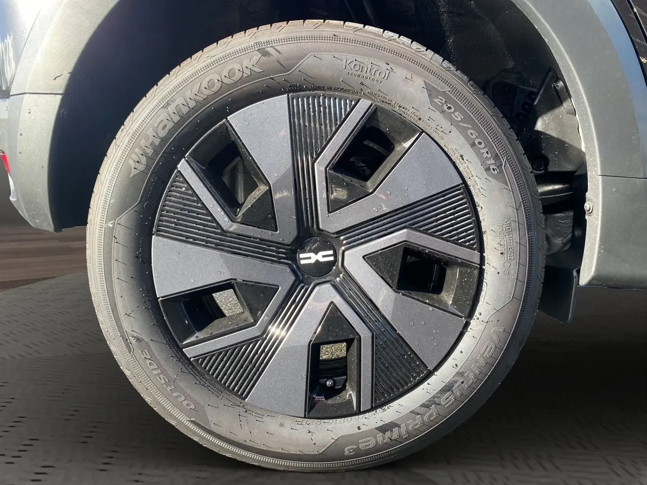 Gros plan sur la roue avant droite noire de la Dacia Sandero Stepway 2025 avec jante au design géométrique moderne.