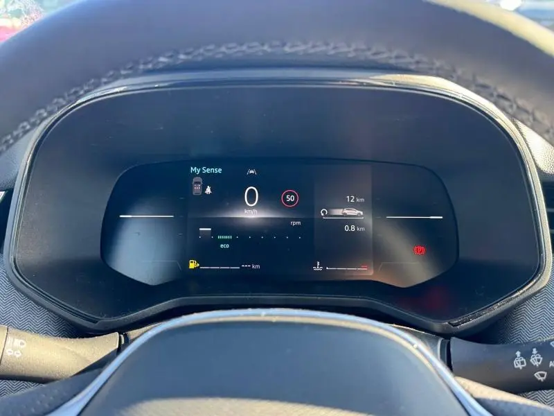 Vue rapprochée du tableau de bord numérique de la Renault Clio orange 2025, affichant la vitesse et les aides à la conduite.