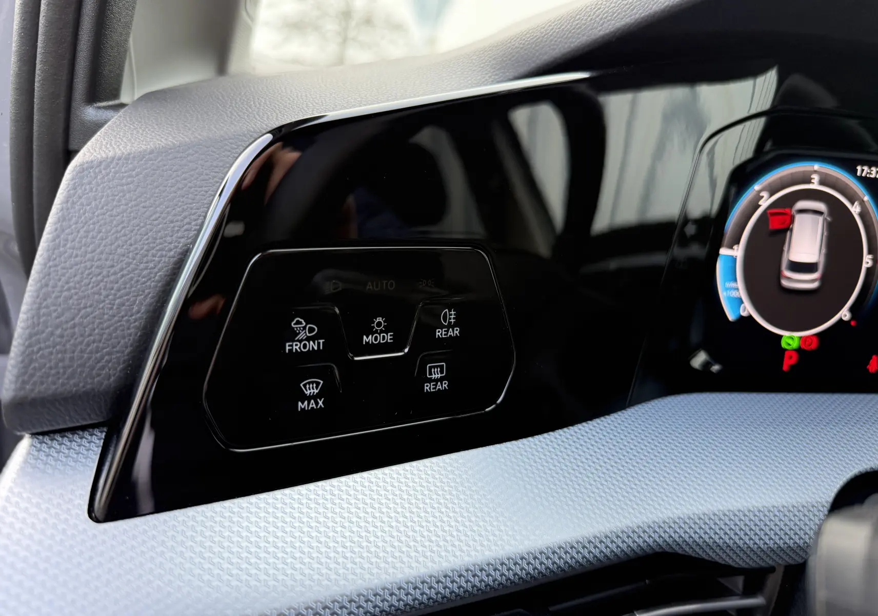 Détail du tableau de bord noir brillant de la Volkswagen Golf SW 2.0 TDI 150 gris lunaire, avec commandes d’éclairage et affichage digital.