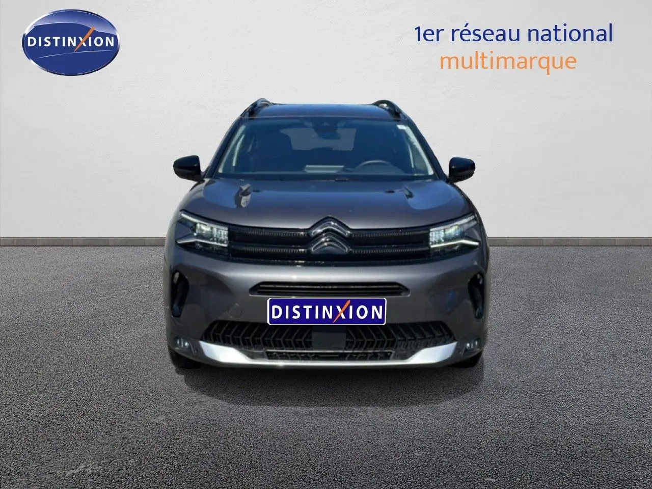 Vue frontale d'un Citroën C5 Aircross gris platinium métal avec calandre distinctive et phares LED allumés.