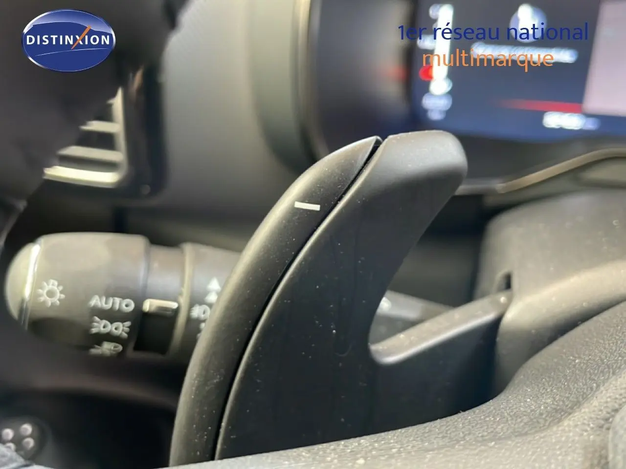 Gros plan sur la palette de changement de vitesse au volant d’un Citroën C5 Aircross gris platinium, intérieur visible flou.