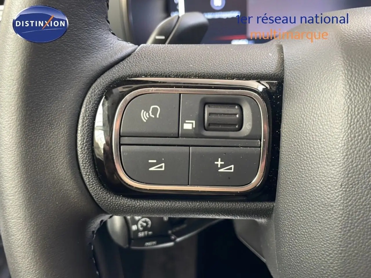 Gros plan sur les commandes de volume et appel du volant en cuir du Citroën C5 Aircross 2025 gris platinium.