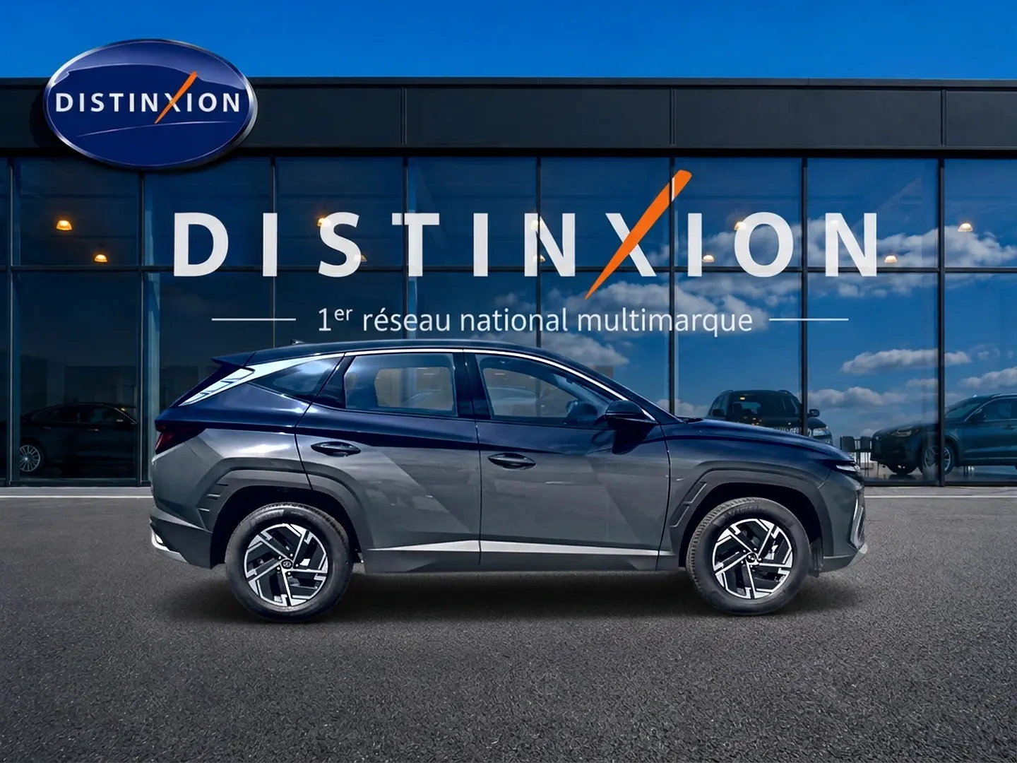 Vue de profil côté gauche du Hyundai Tucson 2026 gris ecotronique avec jantes alliage et lignes anguleuses marquées.