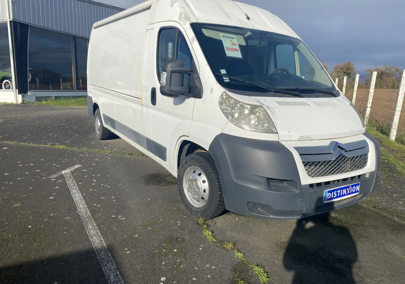 Vue 3/4 avant droite d'un utilitaire Citroën Jumper blanc avec pare-chocs noir et plaque Distinxion.