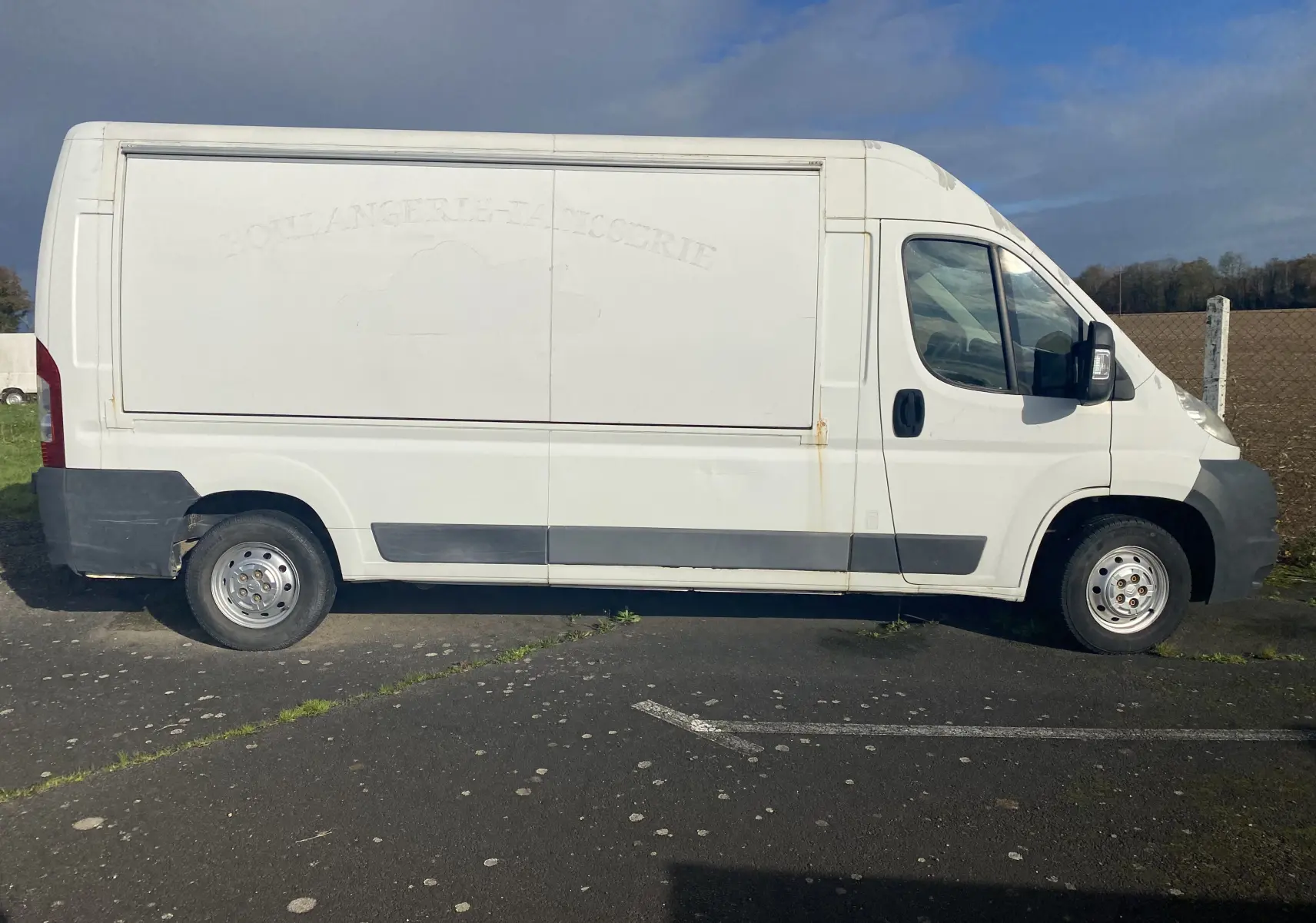 Vue latérale gauche d'un utilitaire blanc Citroën Jumper L3H2 2011 avec marquage effacé sur la caisse.