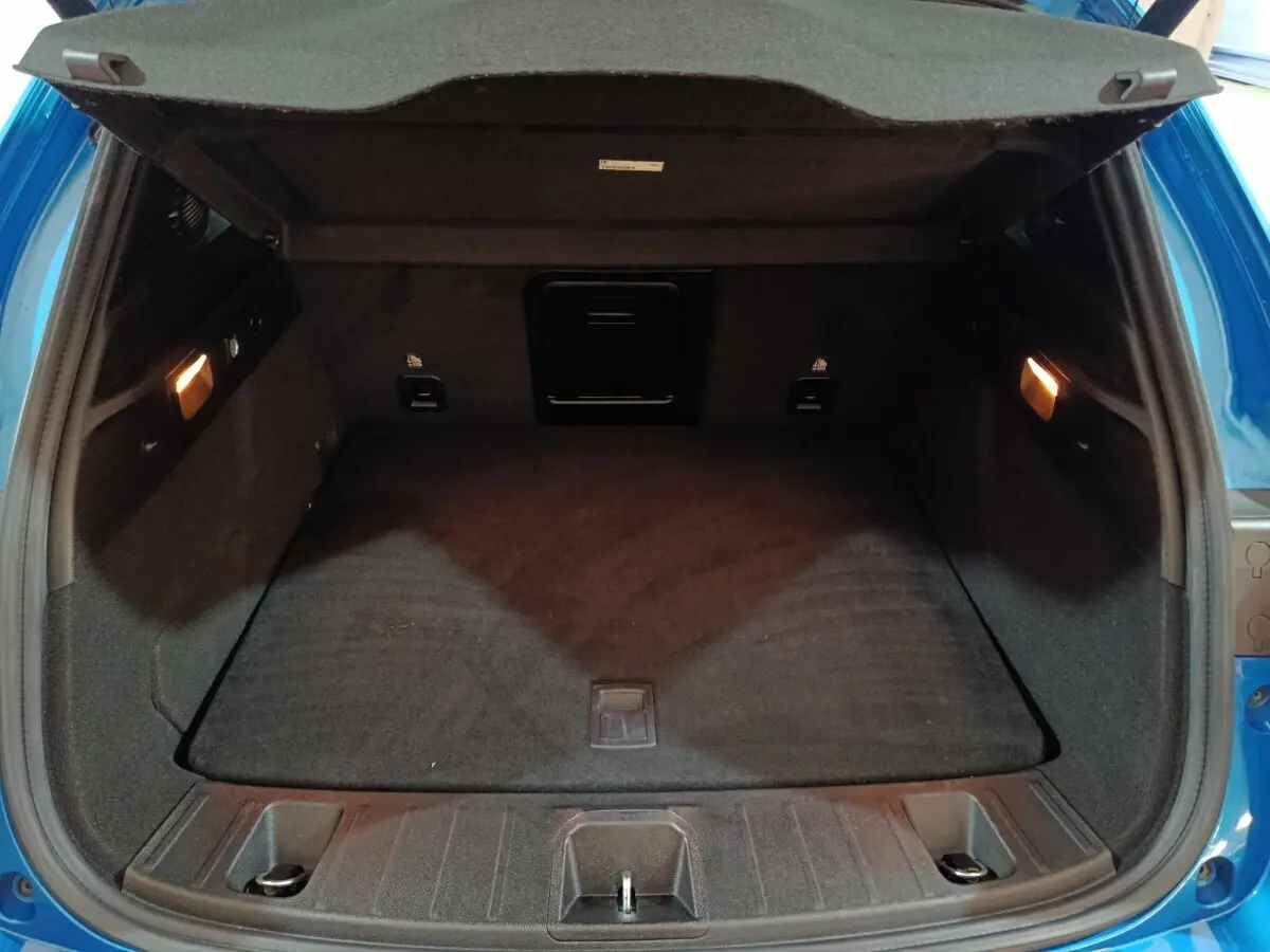 Coffre ouvert de l'Alfa Romeo Tonale bleu 2023, vue arrière montrant l'espace de chargement et l'éclairage intérieur.