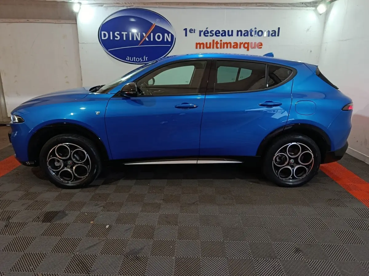 Vue de profil côté gauche d'un Alfa Romeo Tonale bleu 2023 avec jantes distinctives et logo Ti sur la porte avant.