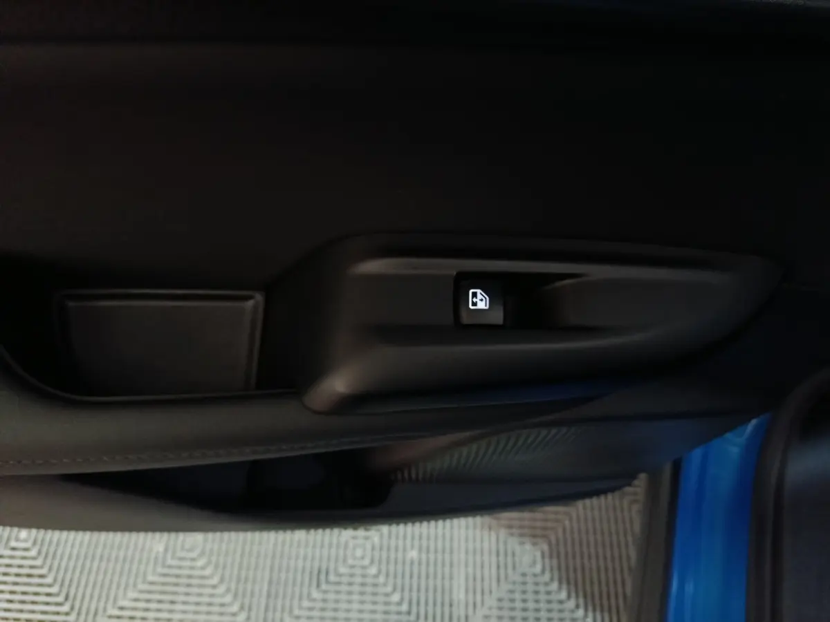 Gros plan sur la commande de verrouillage de porte côté intérieur d'une Alfa Romeo Tonale bleue.