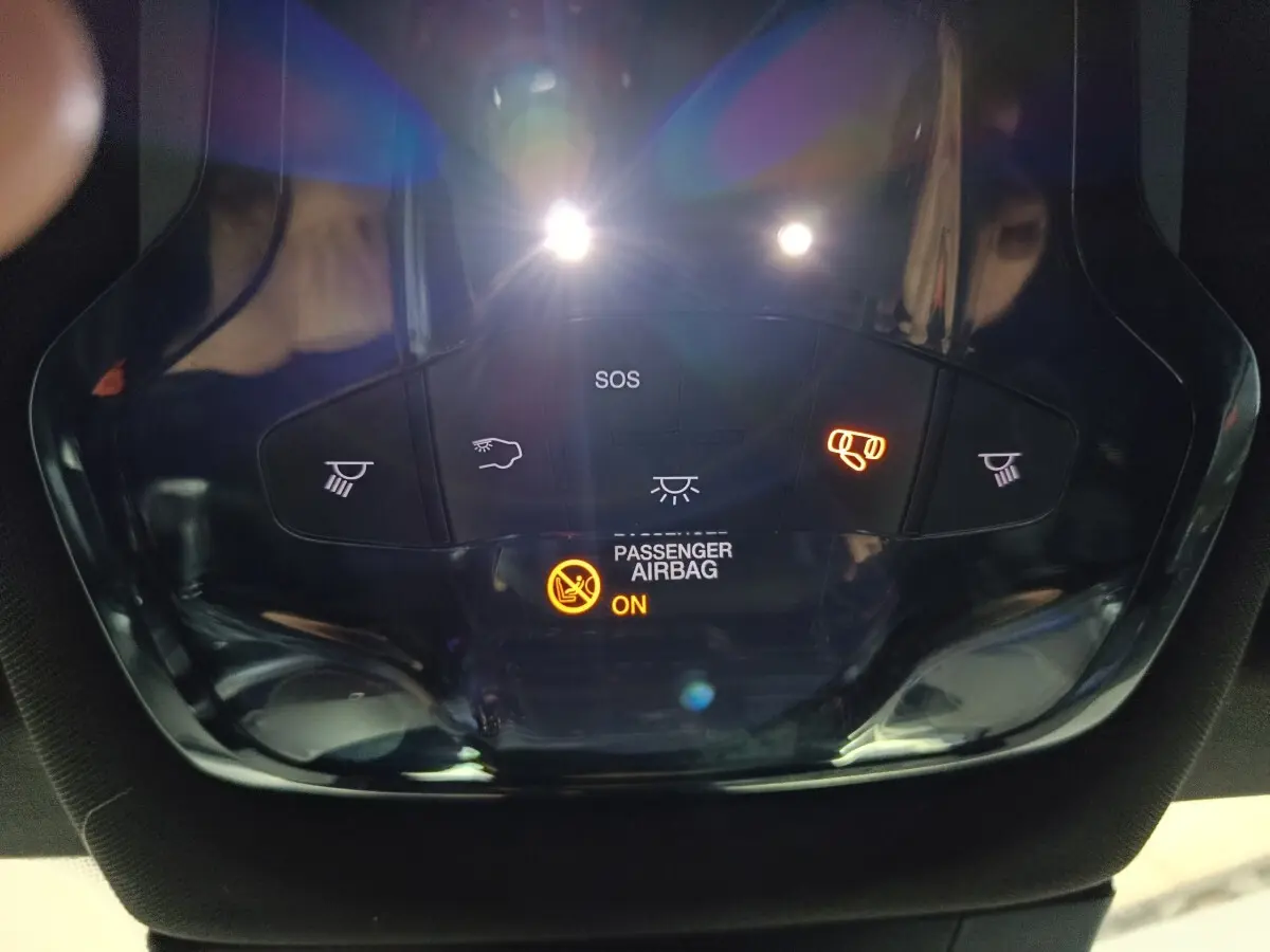 Vue en gros plan du panneau de commande intérieur avec éclairage et indicateur airbag passager activé sur Alfa Romeo Tonale bleu.