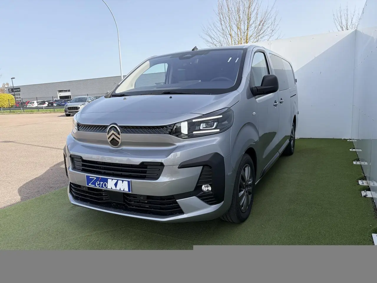 Vue 3/4 avant d'un Citroën Jumpy gris acier métal avec calandre noire et jantes alliage 17 pouces grises.