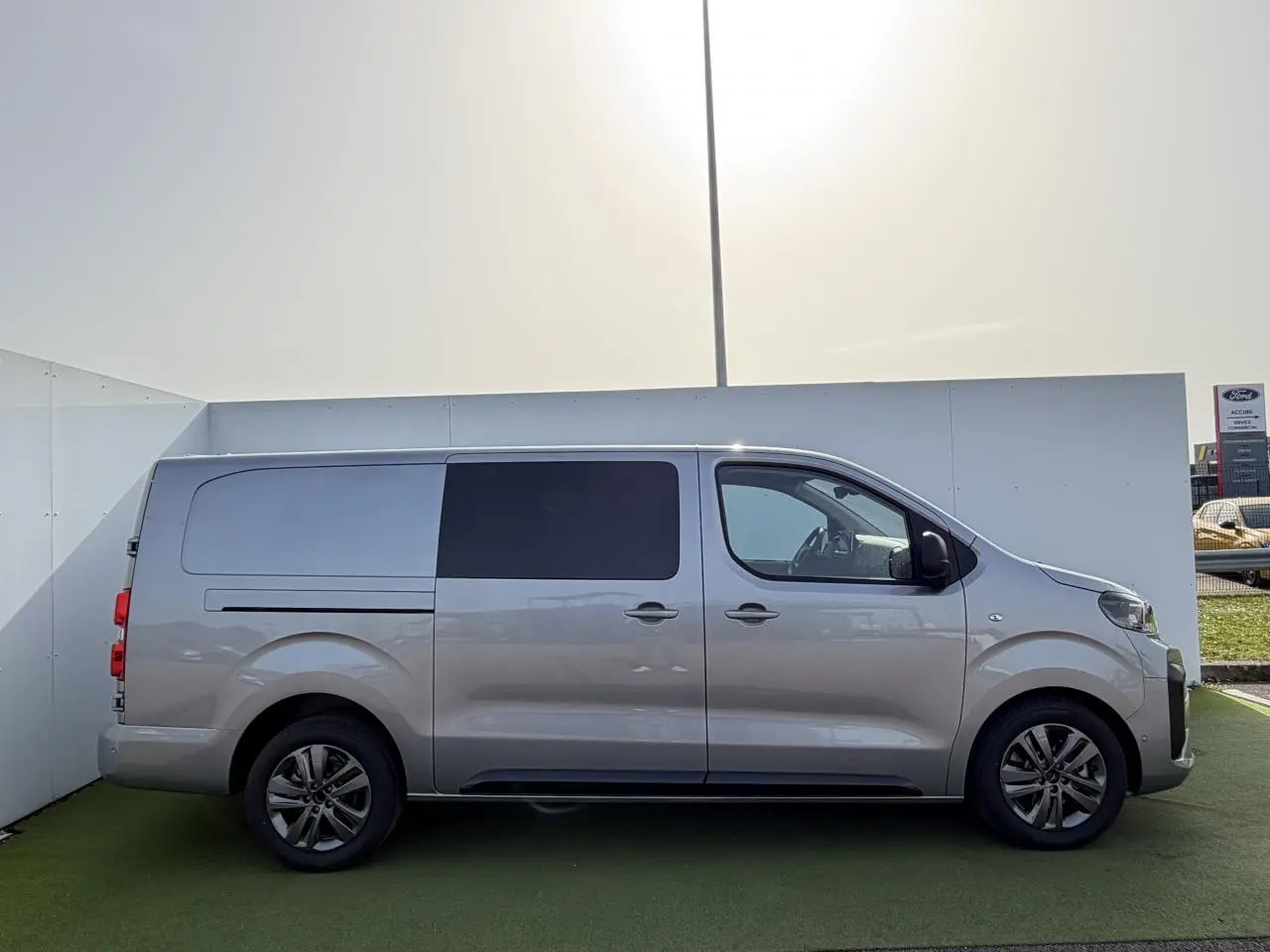 Vue latérale droite d'un Citroën Jumpy gris acier métal avec jantes alliage 17'' et vitres latérales extra-teintées.