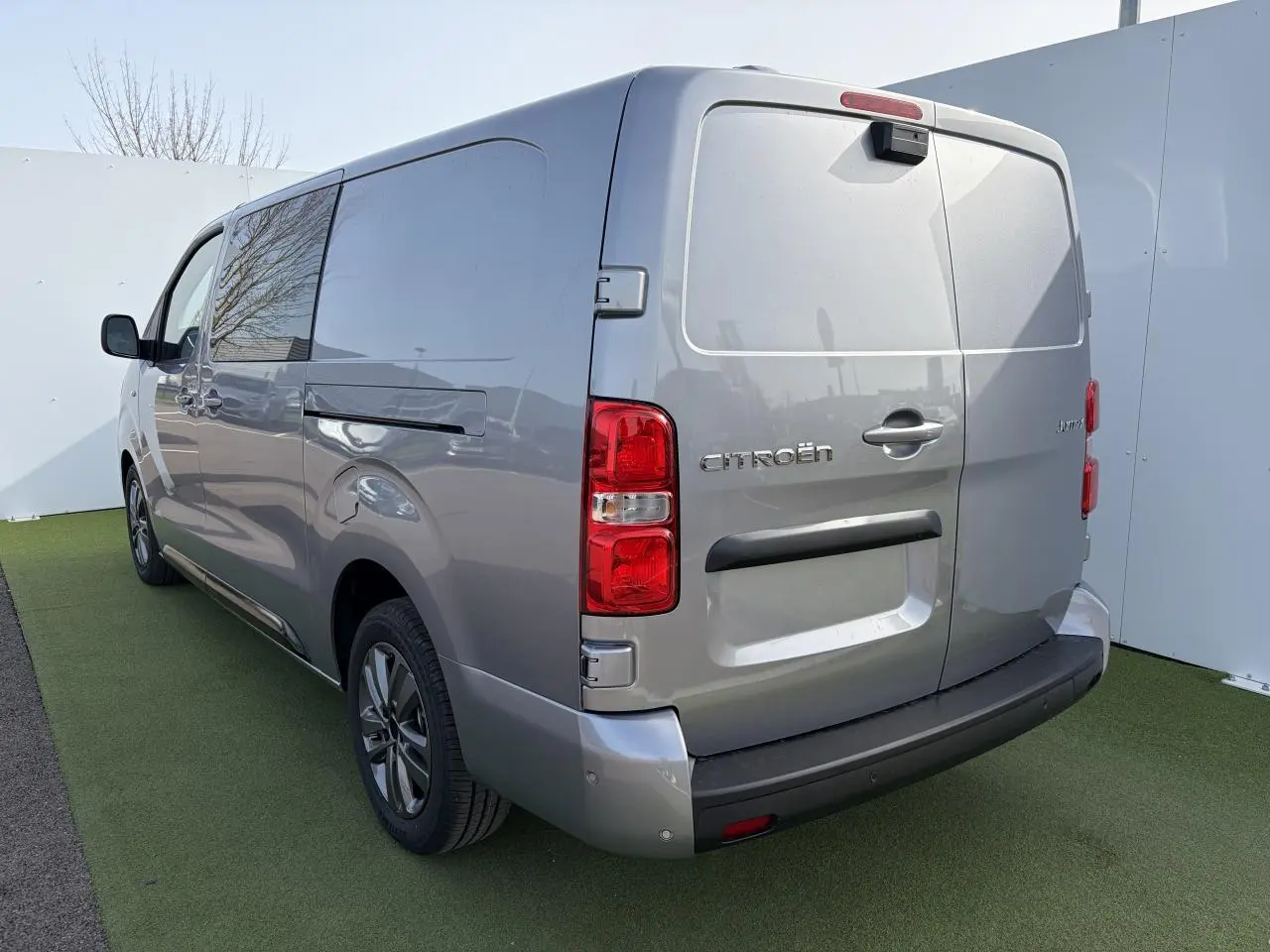 Vue 3/4 arrière droite d'un Citroën Jumpy gris acier métal avec jantes alliage 17'' et portes arrière tôlées.