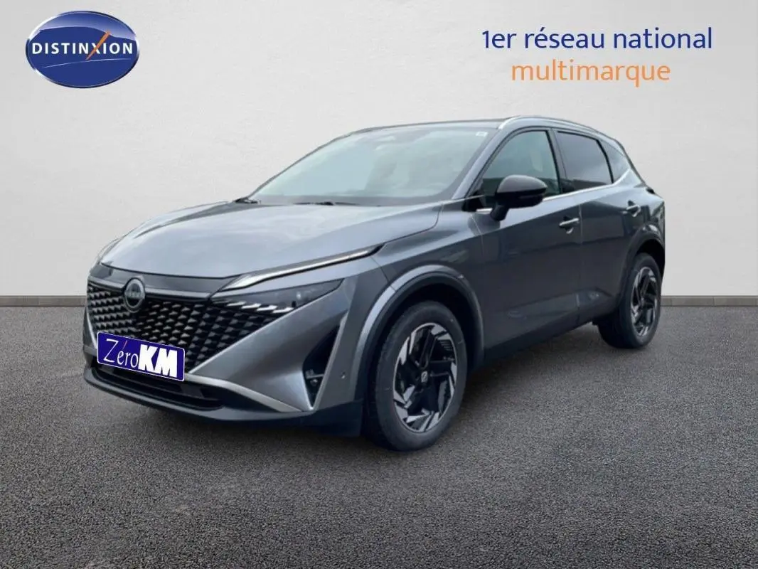 Nissan Qashqai gris 3/4 avant droit avec calandre noire et jantes aluminium au design moderne.