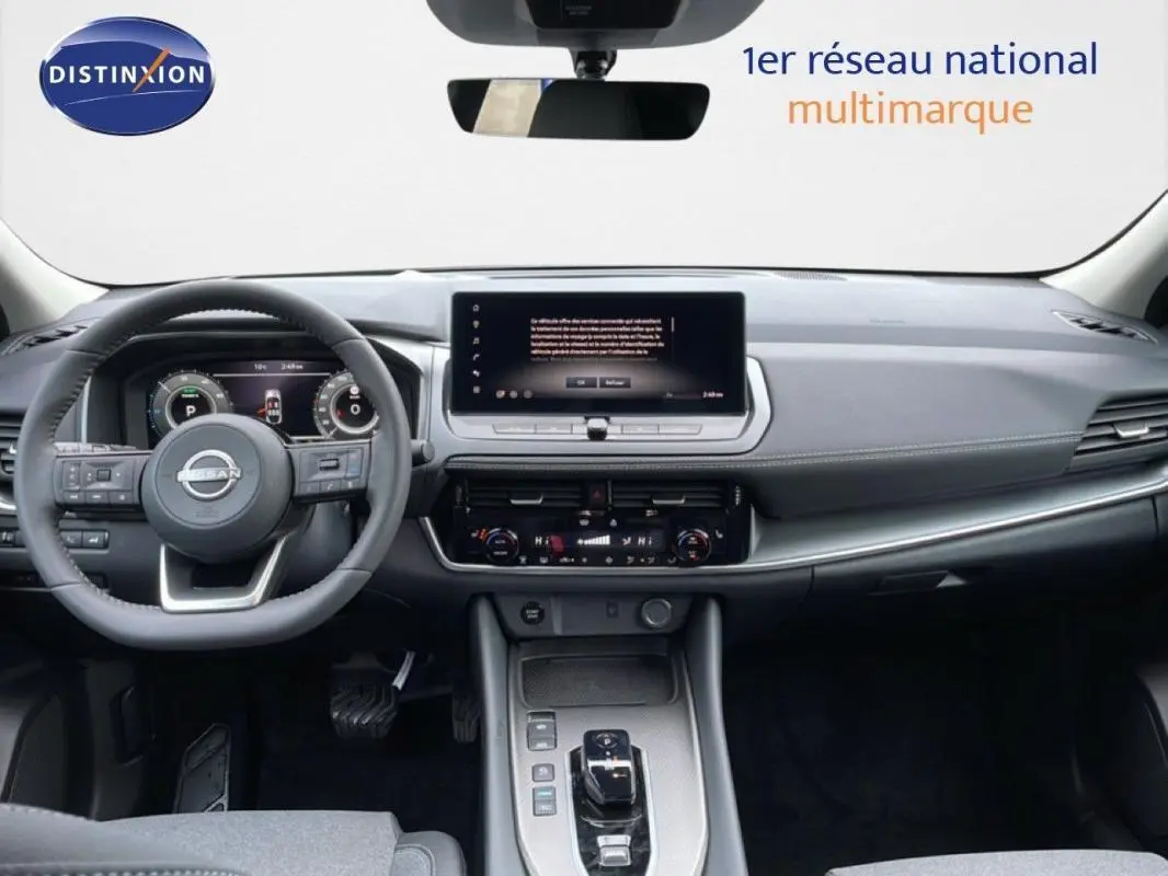 Vue intérieure frontale du tableau de bord gris du Nissan Qashqai 2025, avec écran tactile et volant cuir.