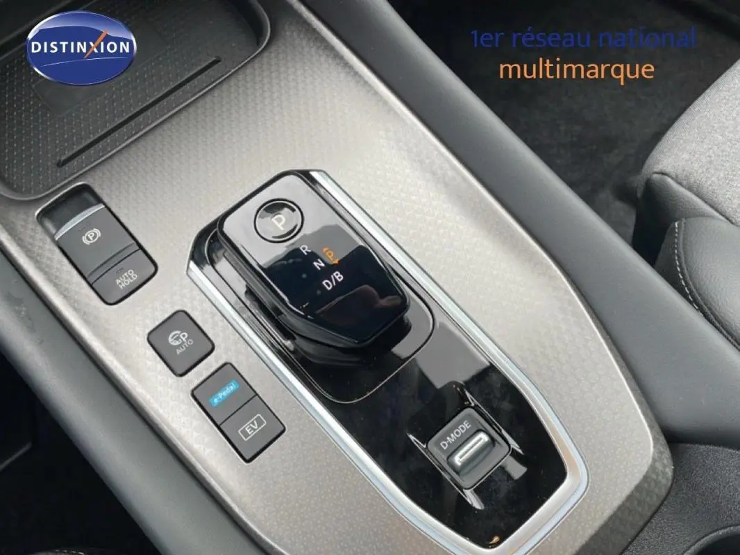 Gros plan sur la console centrale grise du Nissan Qashqai 2025 avec levier de vitesse automatique et boutons de mode de conduite.