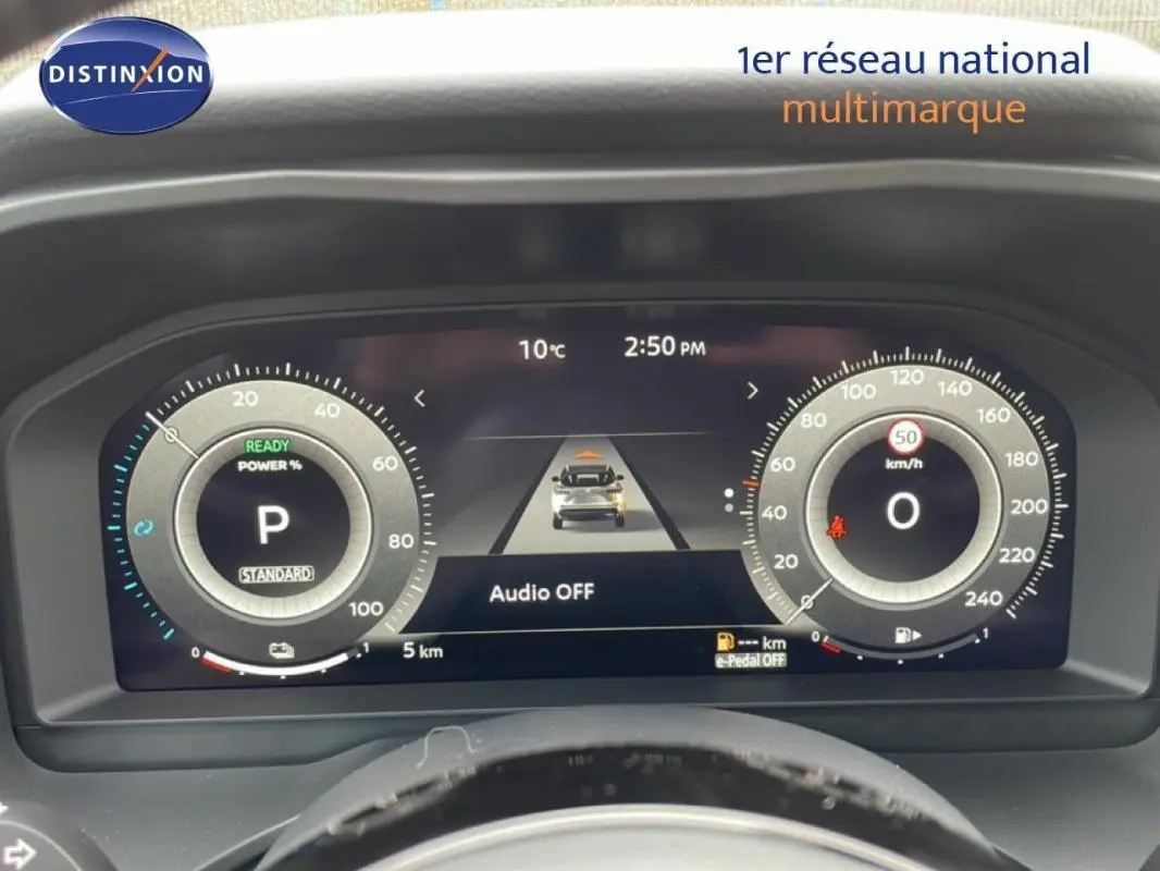 Vue de face du cockpit numérique du Nissan Qashqai gris 2025, affichant la vitesse, la puissance et l'assistance à la conduite.