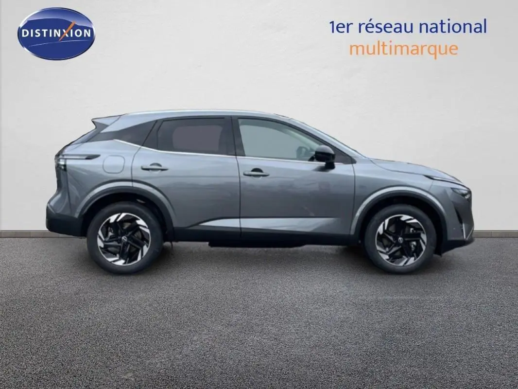 Vue de profil côté gauche d'un Nissan Qashqai gris 2025 avec jantes aluminium et barres de toit visibles.