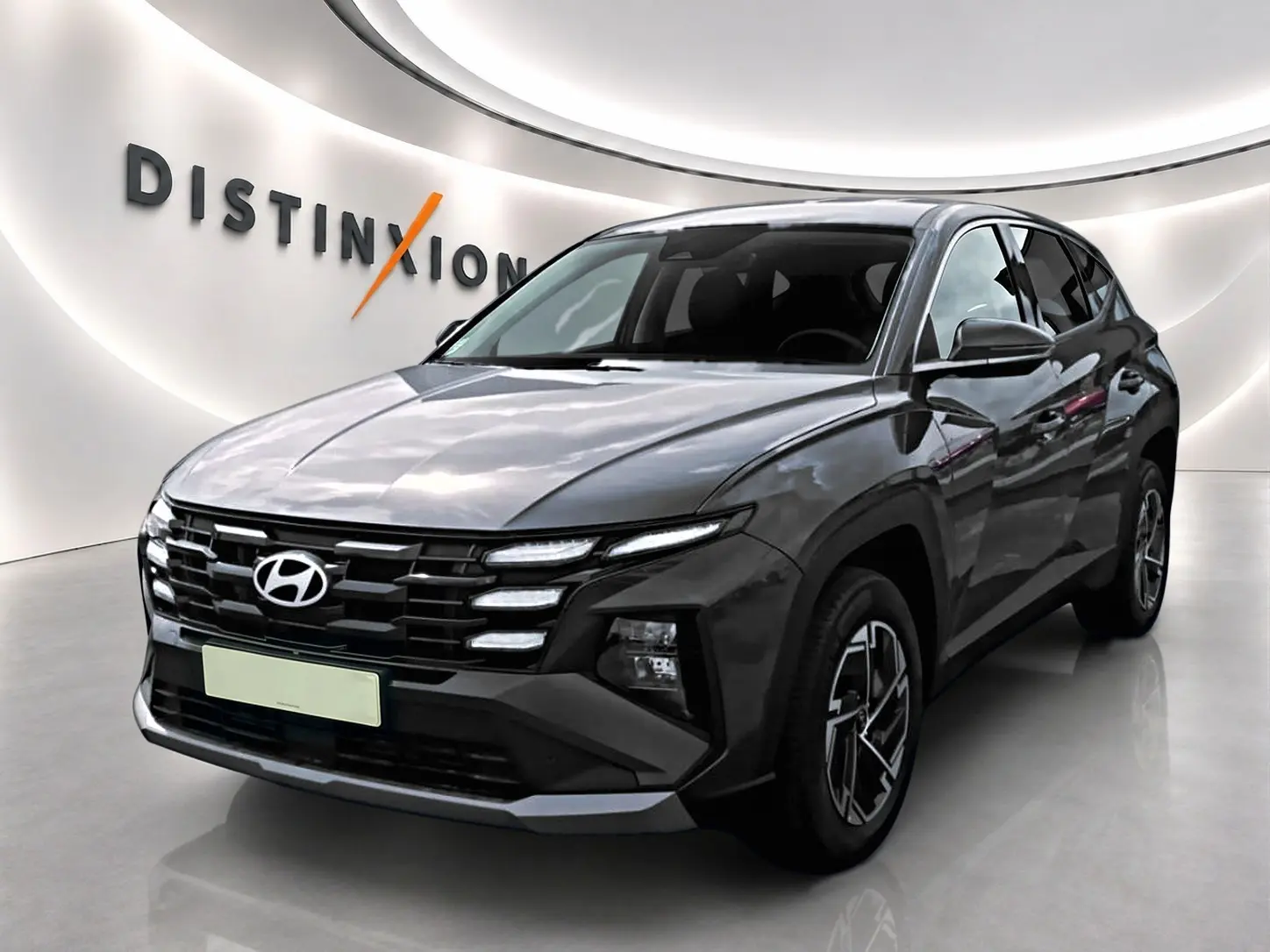 Hyundai Tucson 2026 gris ecotronique en 3/4 avant, avec calandre noire et jantes alliage 17 pouces design moderne.