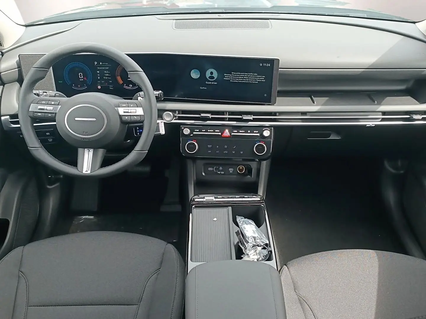 Vue intérieure avant du Hyundai Tucson 2026 gris ecotronique, avec tableau de bord numérique et écran tactile large.