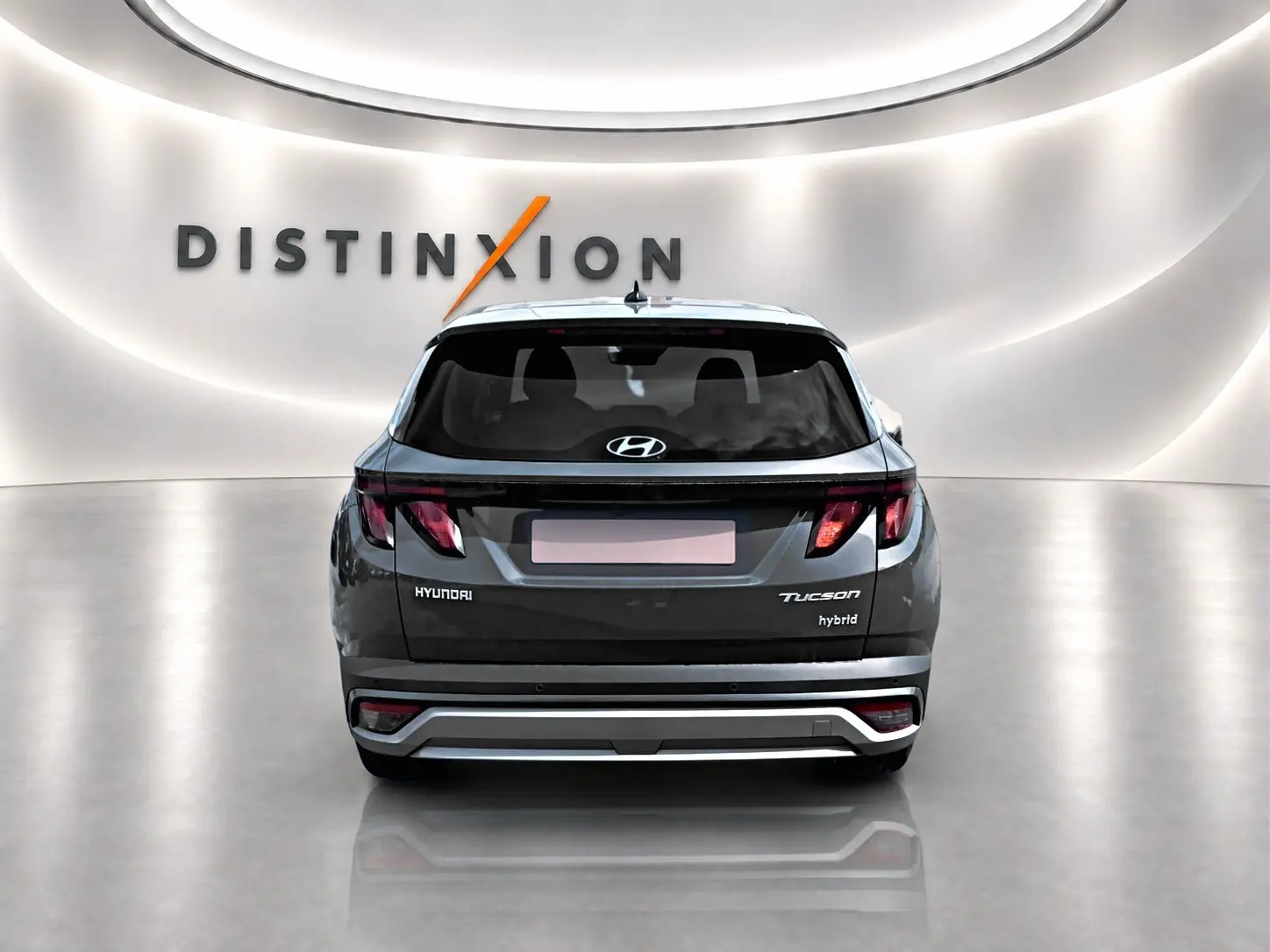 Vue arrière d'un Hyundai Tucson gris ecotronique hybride, avec feux arrière LED et logo Hyundai visible.