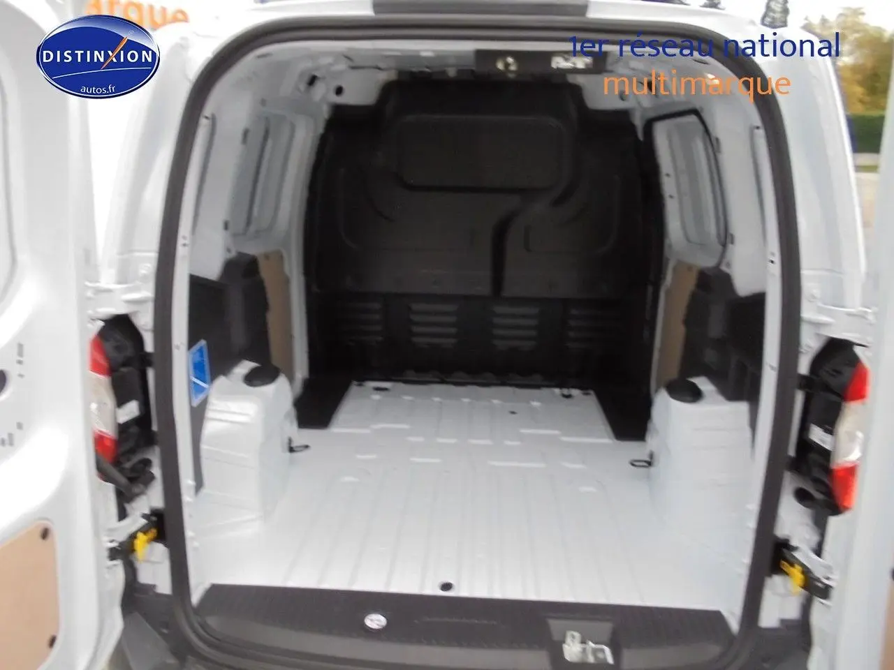 Vue arrière du Ford Transit Courier blanc glacier avec portes ouvertes montrant l'espace de chargement vide.