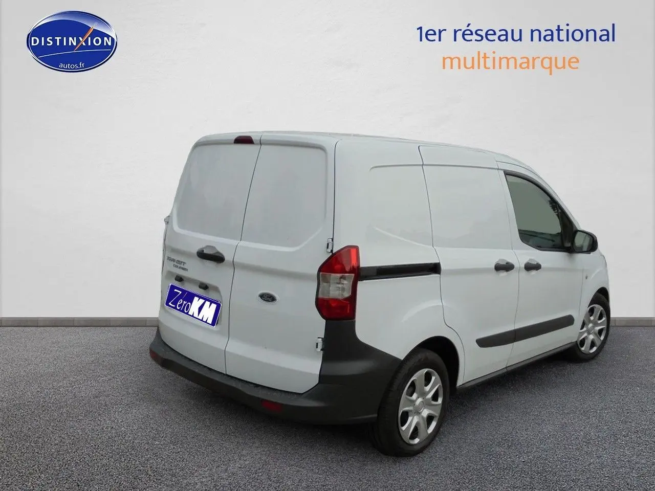 Vue 3/4 arrière droite d'un Ford Transit Fourgon Courier blanc glacier avec portes arrière battantes et protections noires.