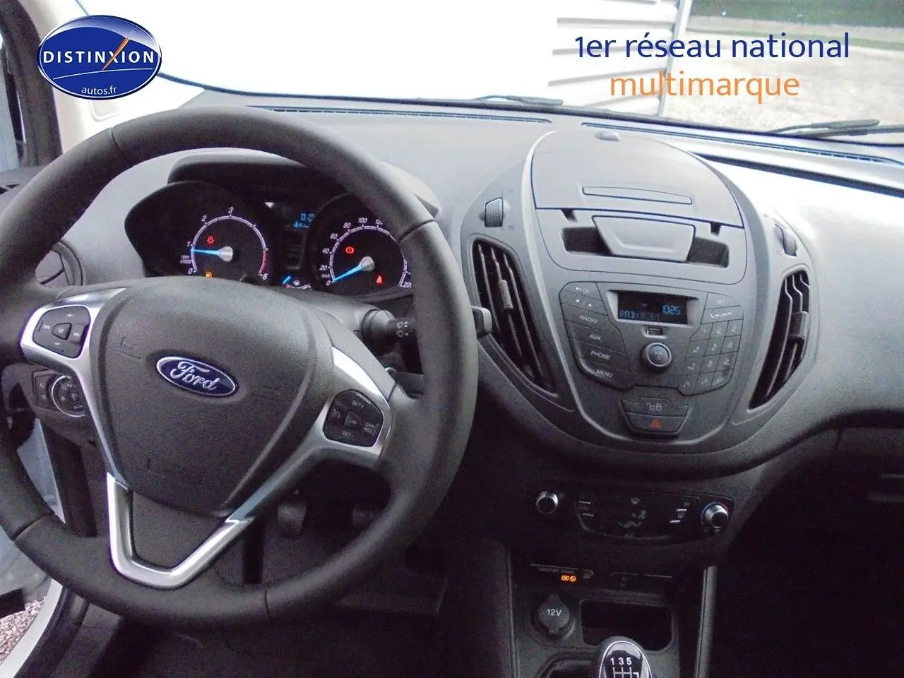 Intérieur du Ford Transit Courier 2022, tableau de bord et volant vus de face, finition noire avec commandes intégrées.