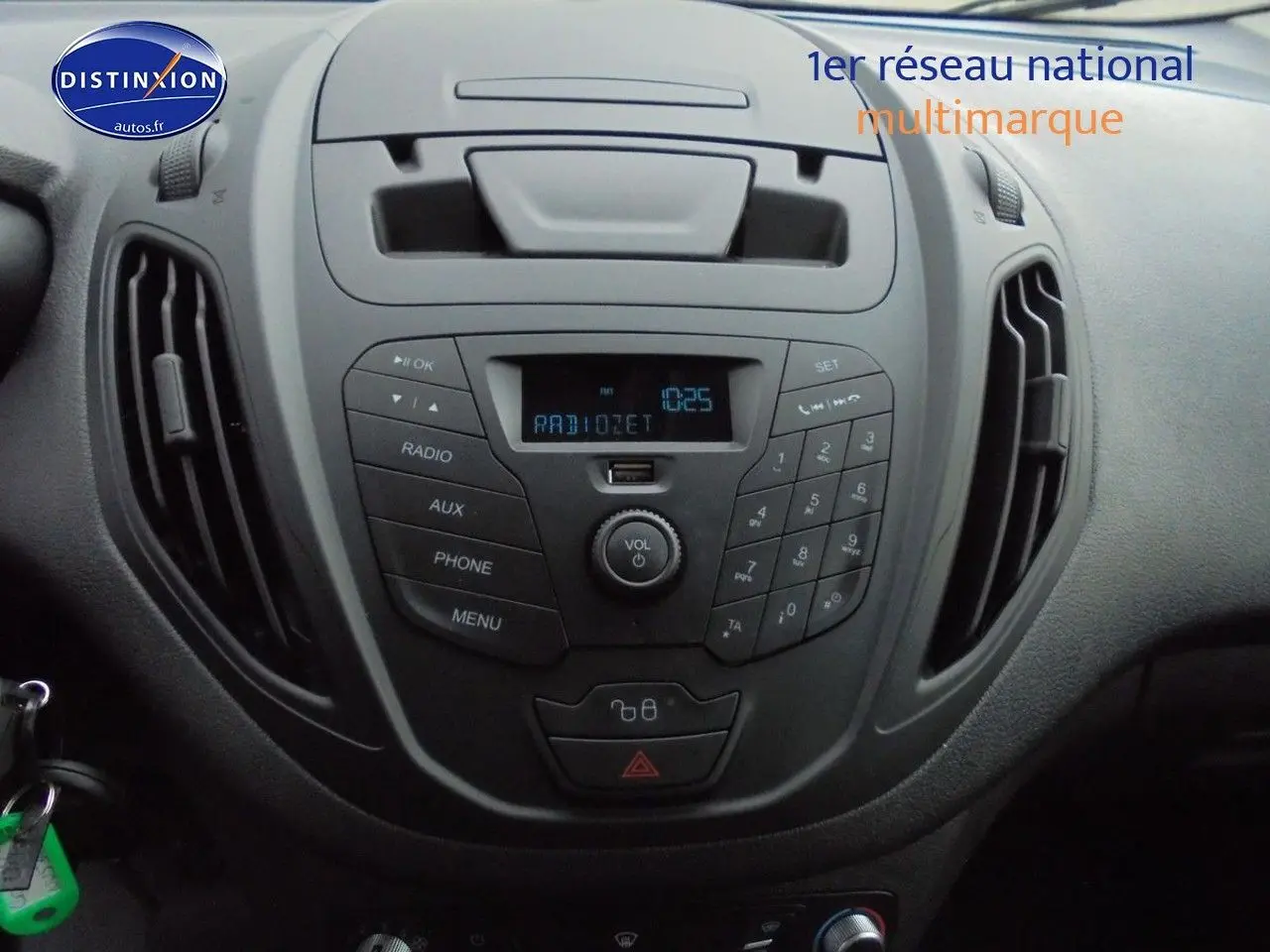 Vue rapprochée du tableau de bord noir du Ford Transit Courier 2022 avec console centrale et commandes radio.