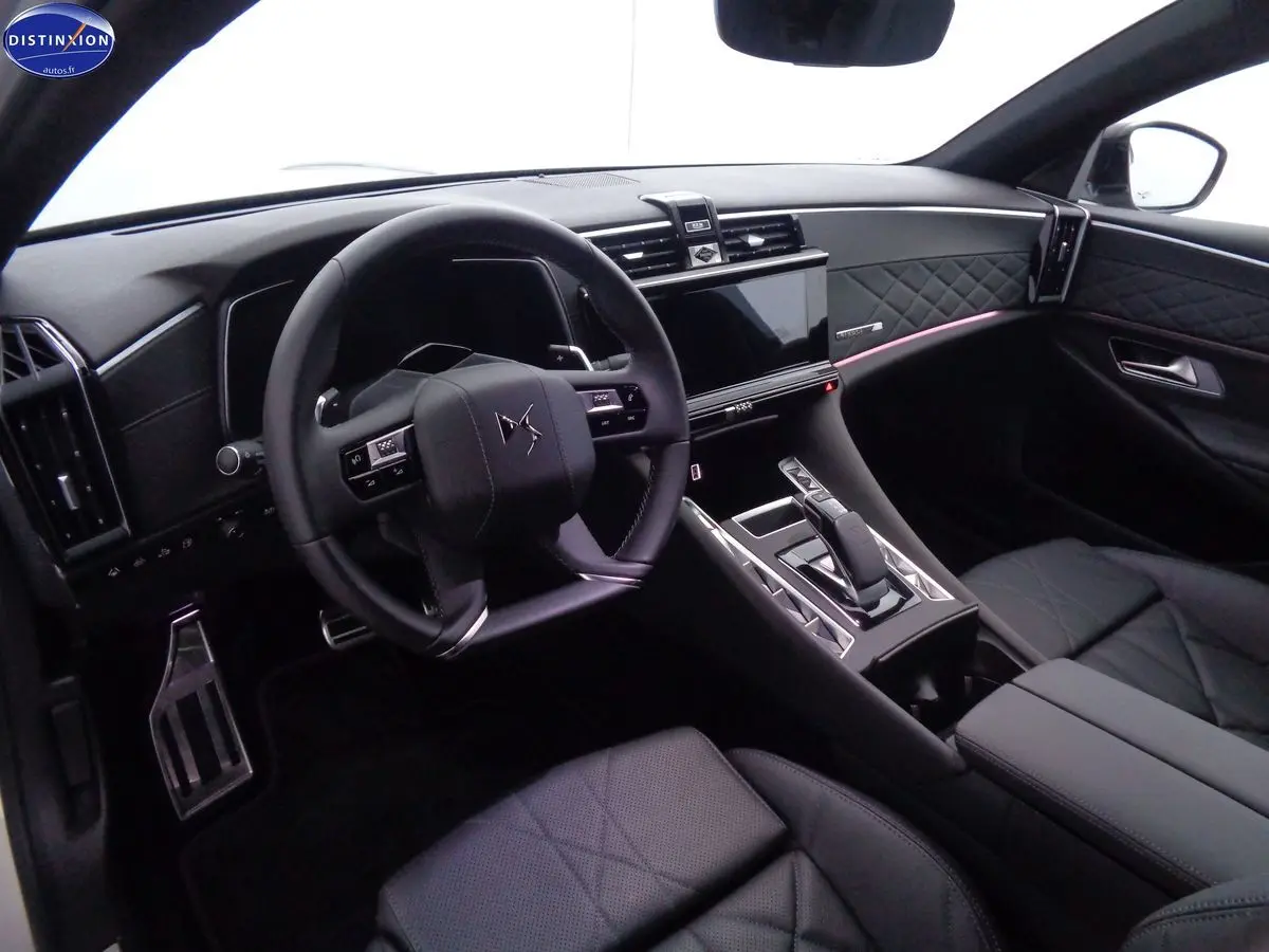Intérieur noir cuir du DS9 hybride rechargeable, vue côté conducteur sur le volant et la console centrale moderne.