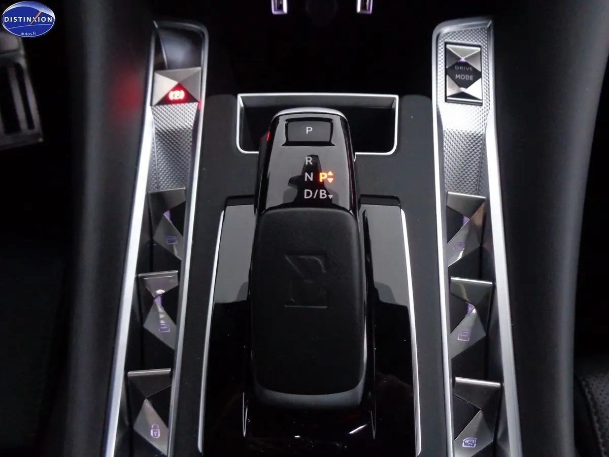 Gros plan sur la console centrale noire du DS9 hybride, mettant en valeur le levier de vitesses et les commandes argentées.