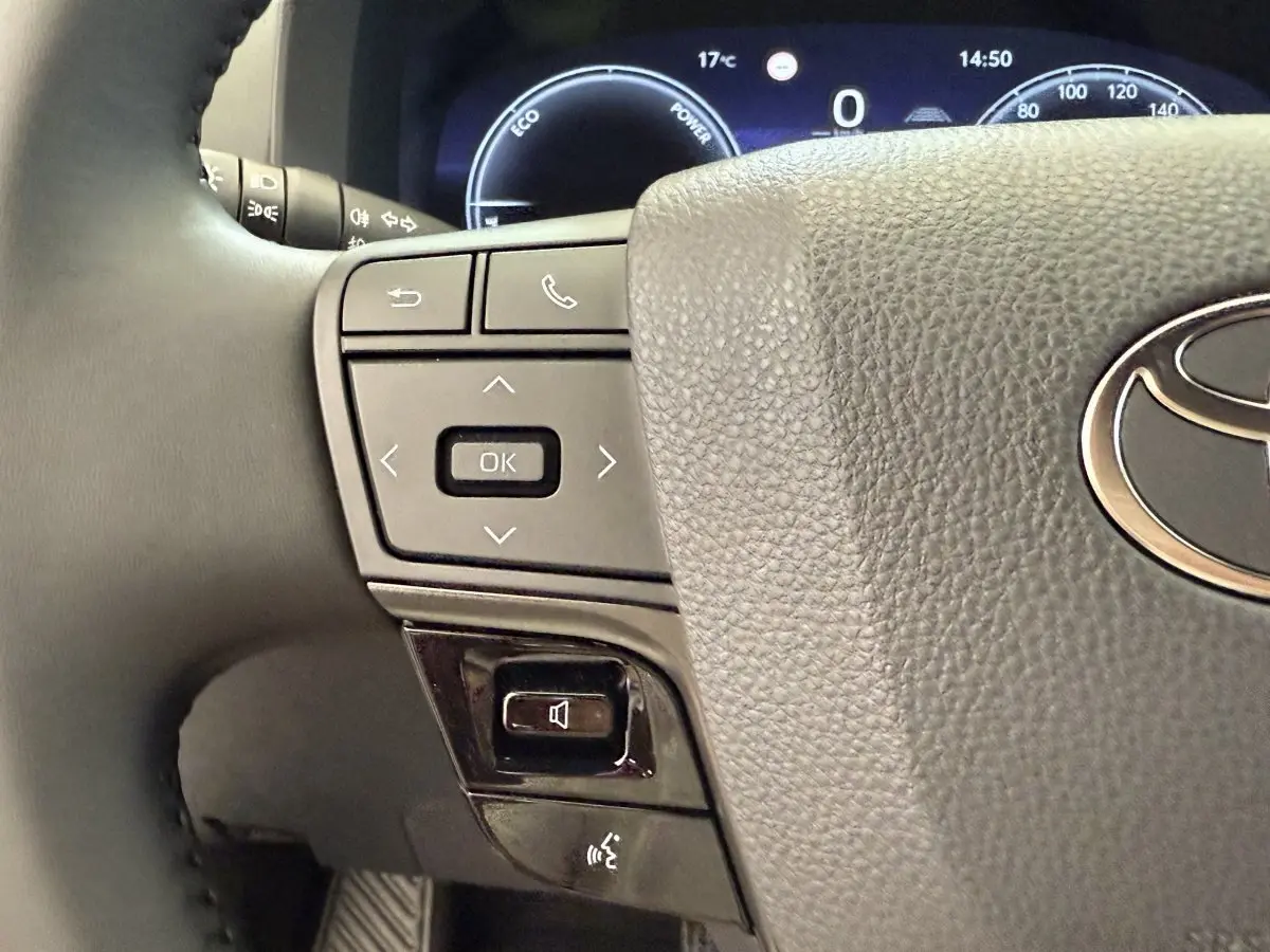 Gros plan sur le volant cuir noir du Toyota C-HR 1.8 Hybride 140 Dynamic 2024 avec commandes multifonctions à gauche.