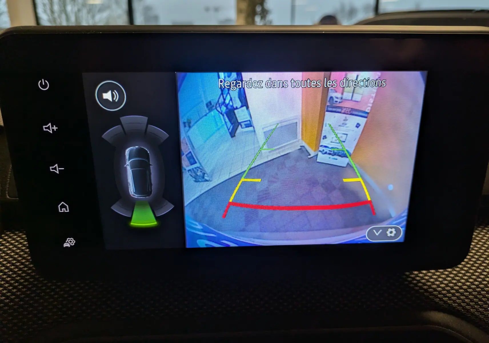 Écran de caméra de recul du Dacia Jogger 2025 montrant l'arrière avec lignes de guidage colorées dans un intérieur lumineux.