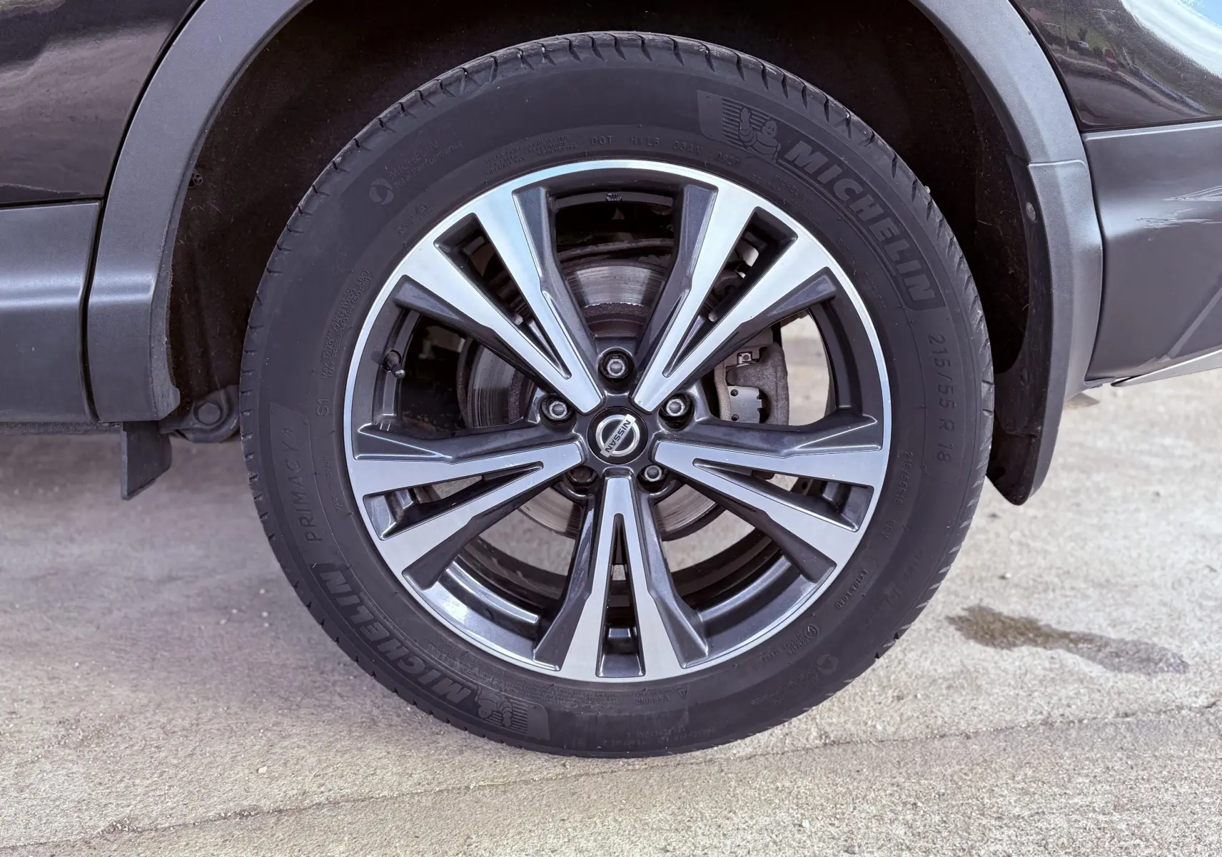 Gros plan sur la roue avant droite du Nissan Qashqai noir, mettant en valeur la jante alliage et le pneu Michelin.