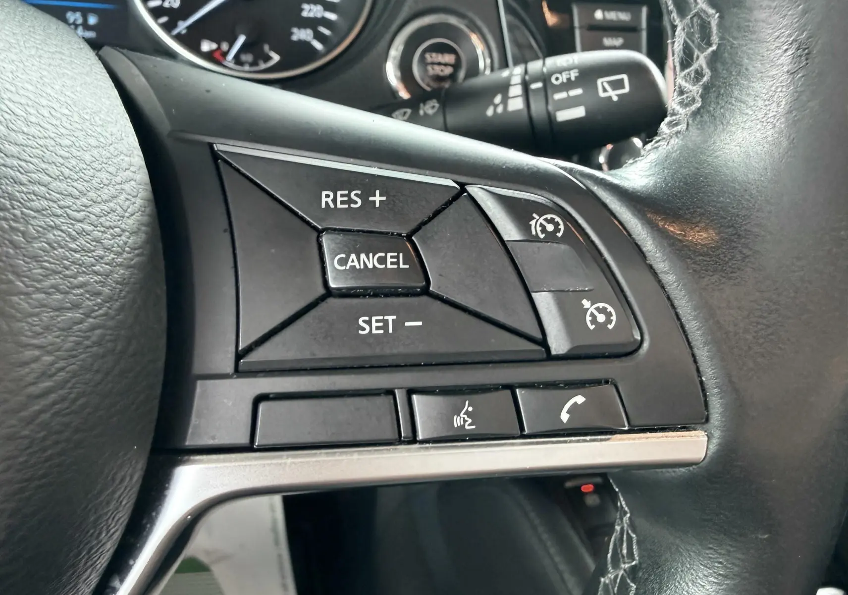 Gros plan sur les commandes de régulateur de vitesse au volant noir du Nissan Qashqai 2020.
