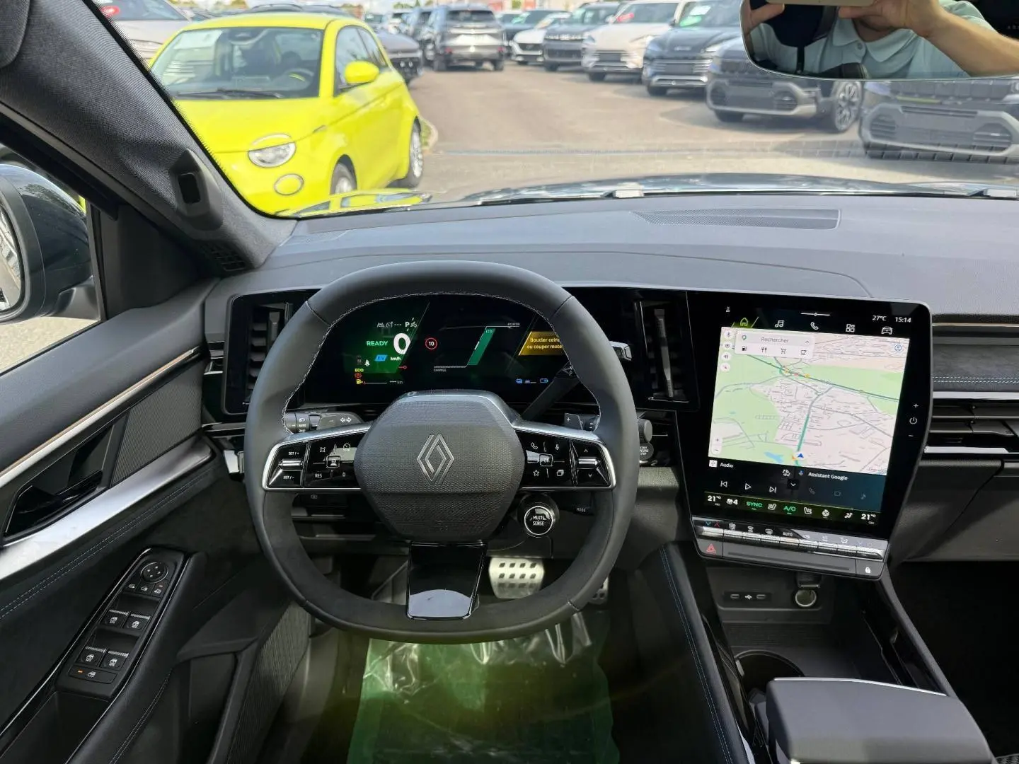 Vue intérieure frontale du tableau de bord du Renault Austral gris, avec volant multifonction et écran tactile vertical.