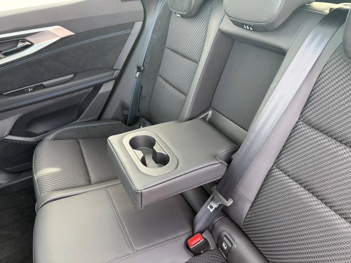 Vue intérieure côté droit sur la banquette arrière gris carbone avec accoudoir central et porte-gobelets du Renault Austral 2026.